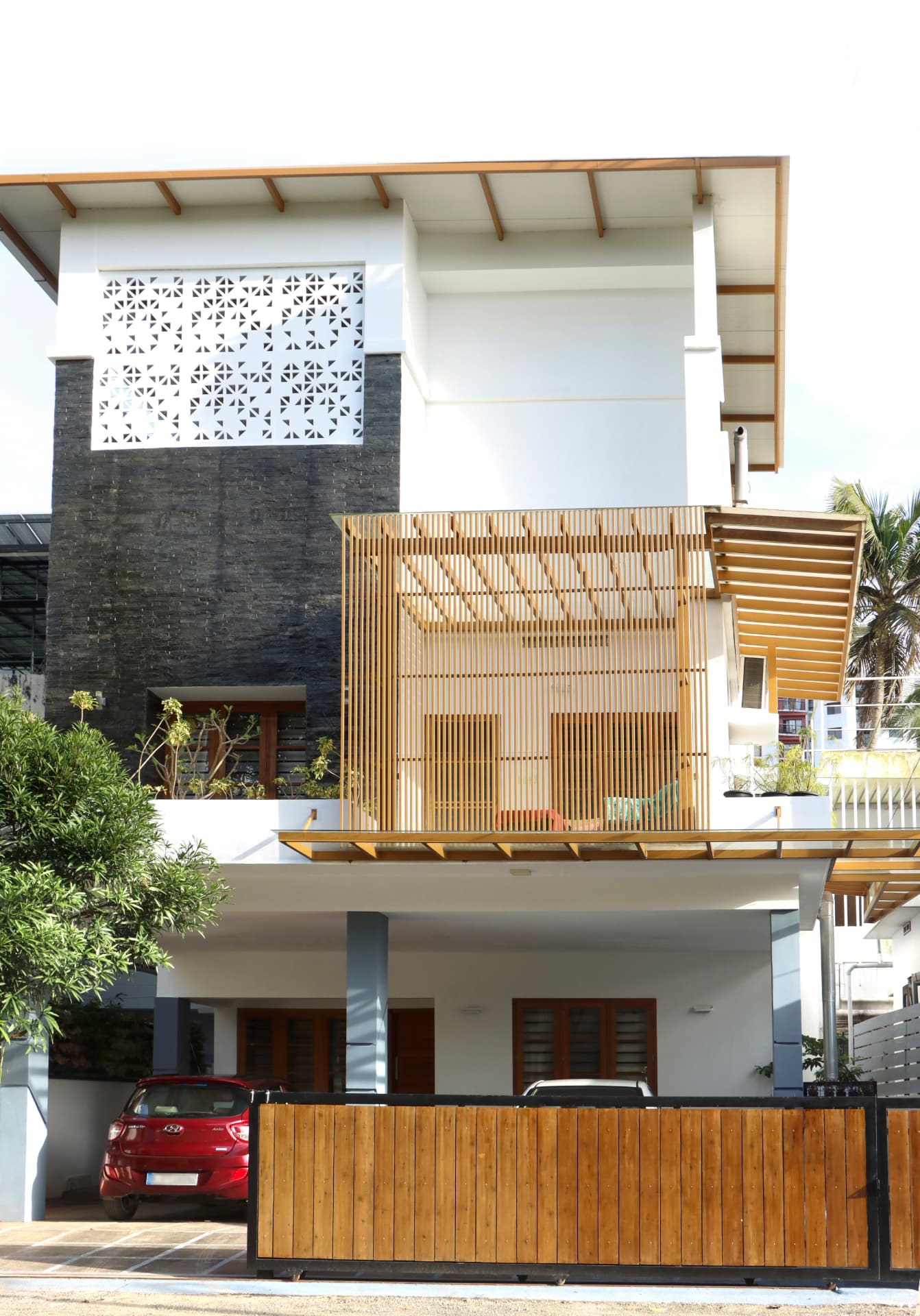 Timber screen façade with jaali panel and stone wall — Exterior work by Alpha Design Studio