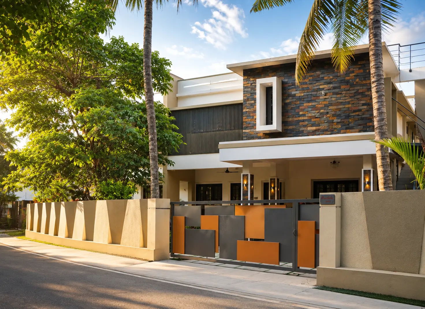 Street-facing home with stone cladding and sculpted gate — Exterior work by Alpha Design Studio