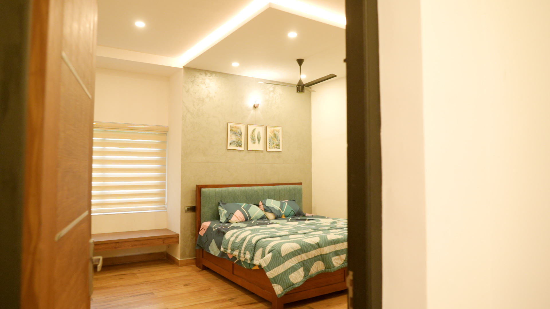 Bedroom with sage headboard and cove-lit ceiling — Interior work by Alpha Design Studio