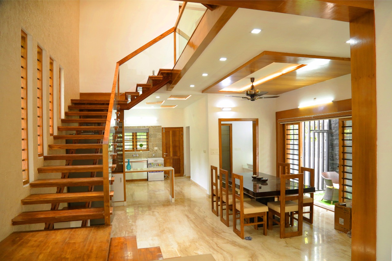 Double-height foyer with timber staircase and dining — Interior work by Alpha Design Studio