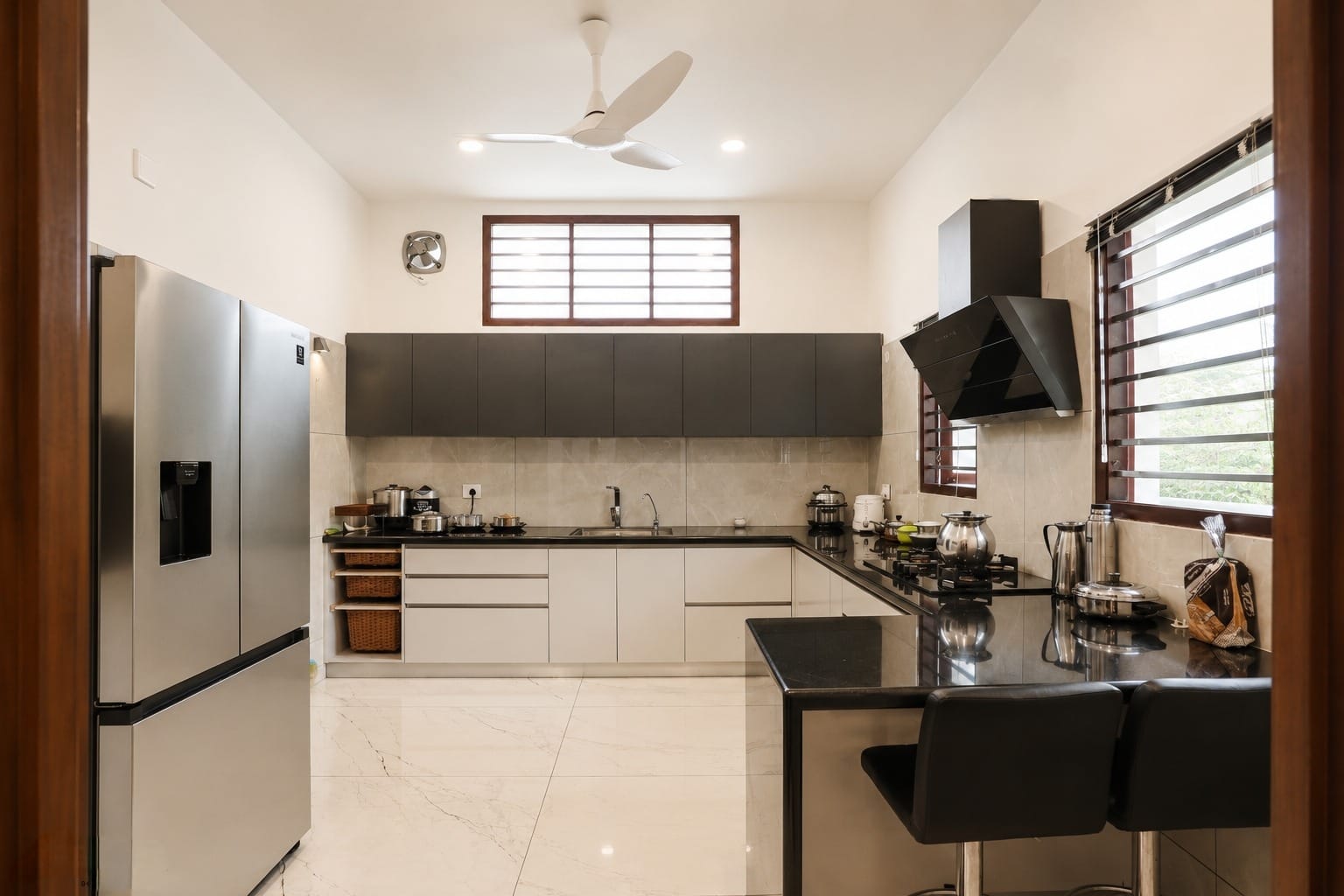 L-shaped modular kitchen in graphite and ivory — Interior work by Alpha Design Studio